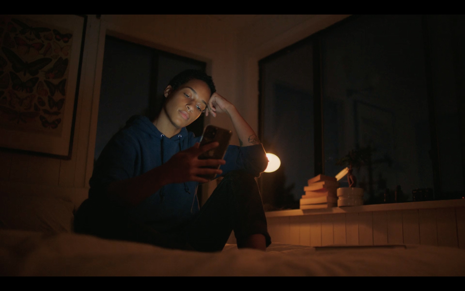 a person sitting on a bed looking at a cell phone