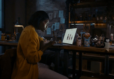 a woman sitting at a table using a laptop computer