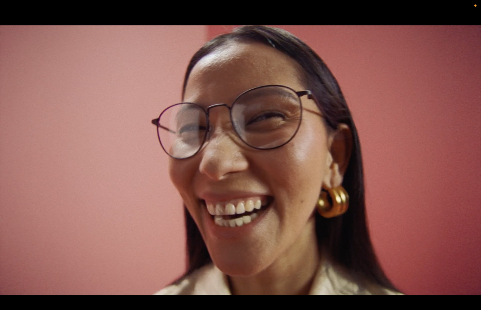 a woman wearing glasses and smiling for the camera