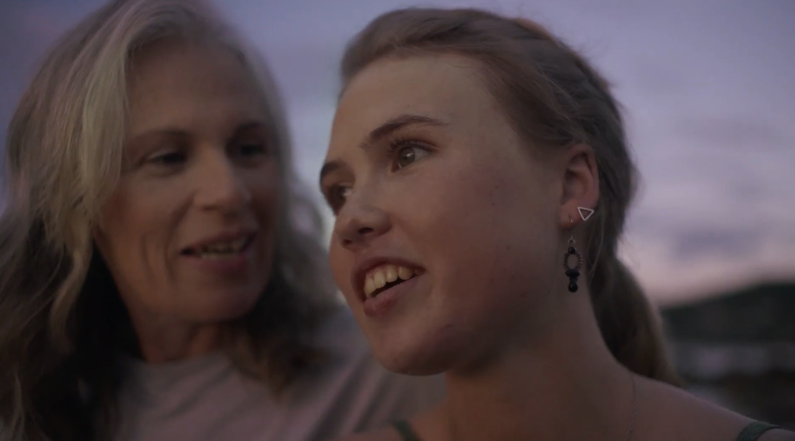 two women looking at each other at dusk