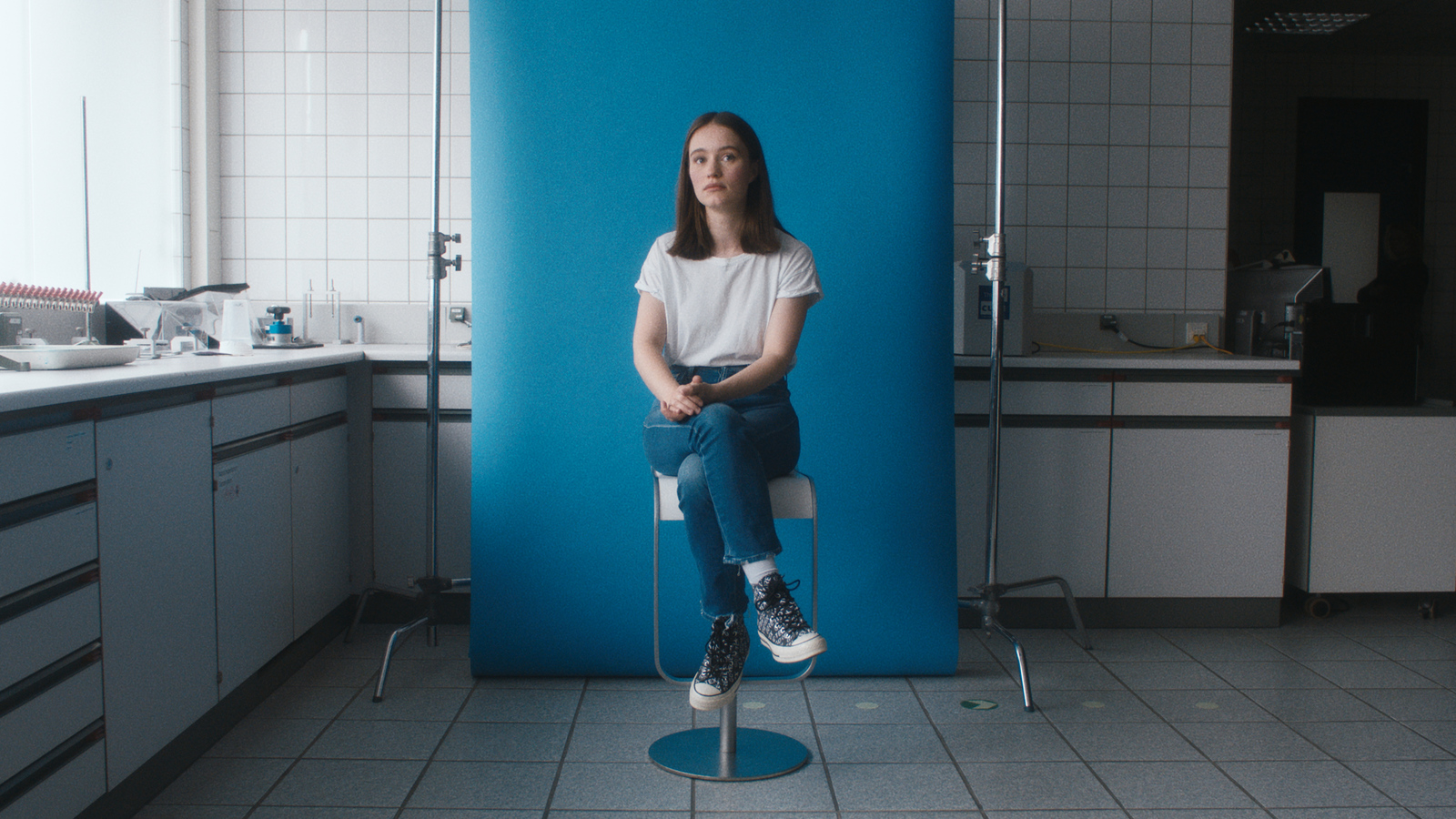 a woman sitting on a chair in a bathroom