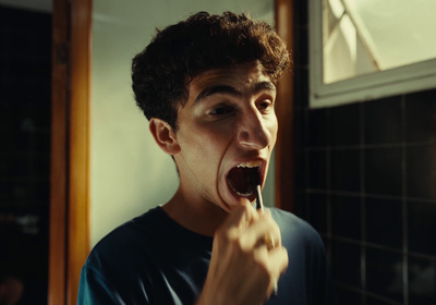 a young man brushing his teeth in the bathroom