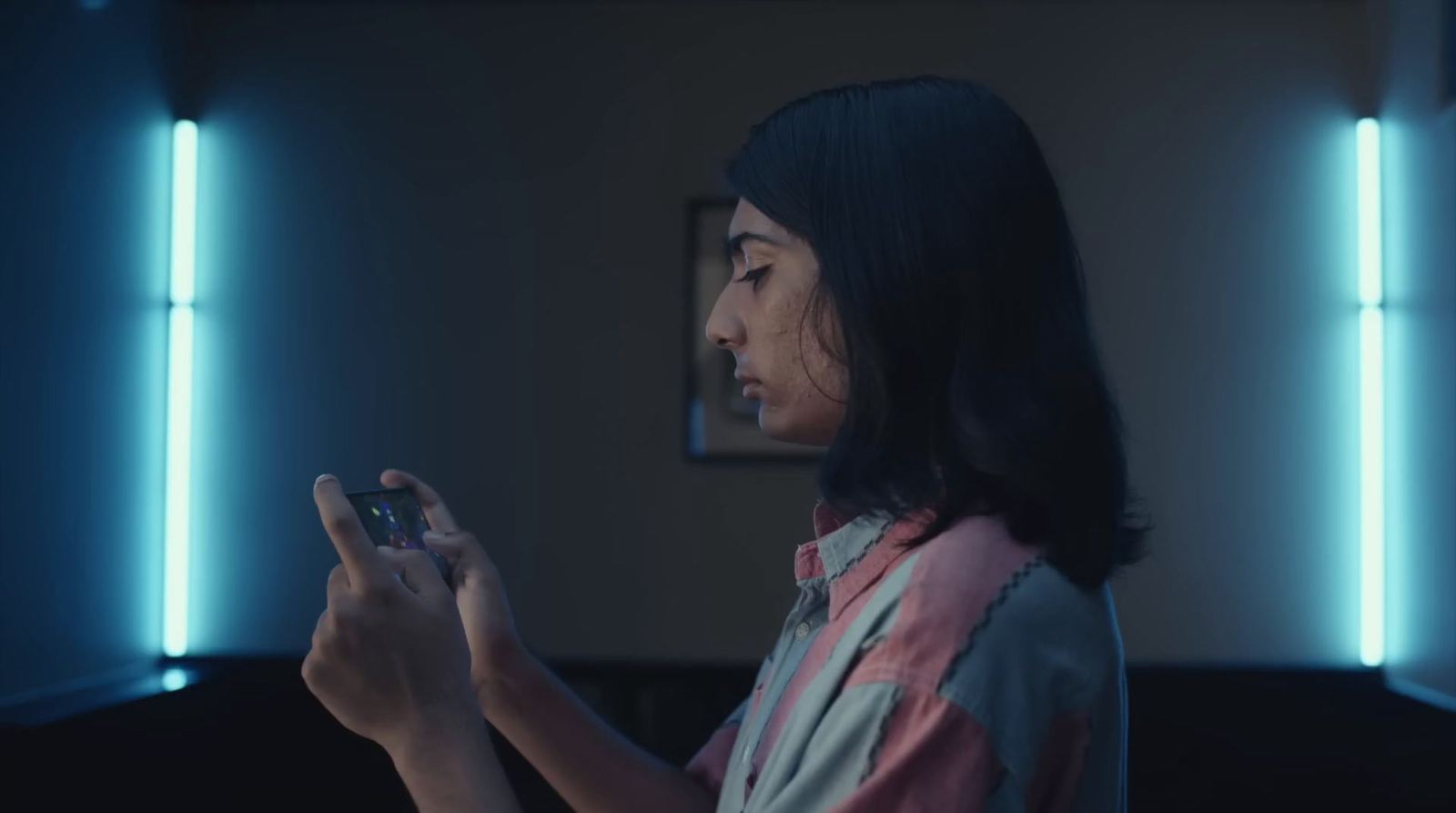 a woman standing in a room holding a cell phone