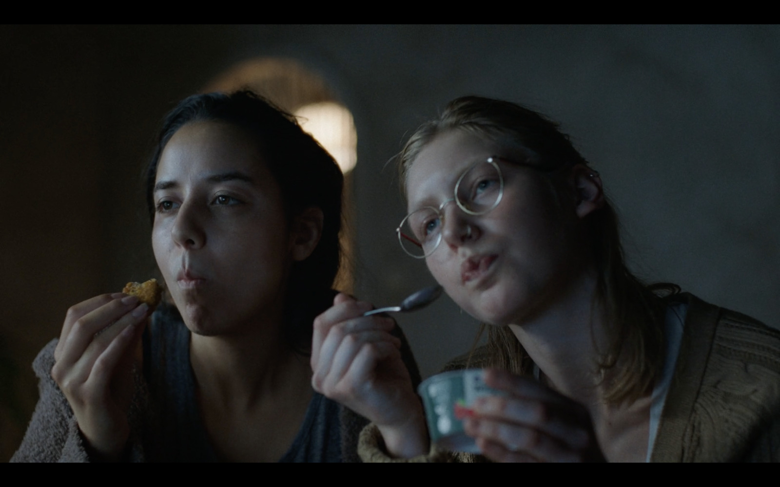 two women are eating food and drinking coffee