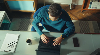 a man sitting at a desk using a laptop computer