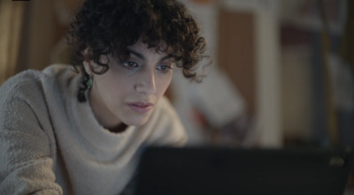 a woman sitting in front of a laptop computer