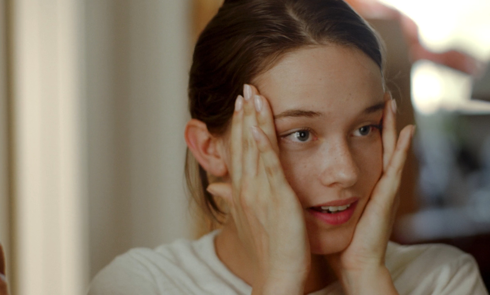 a young girl with her hands on her face