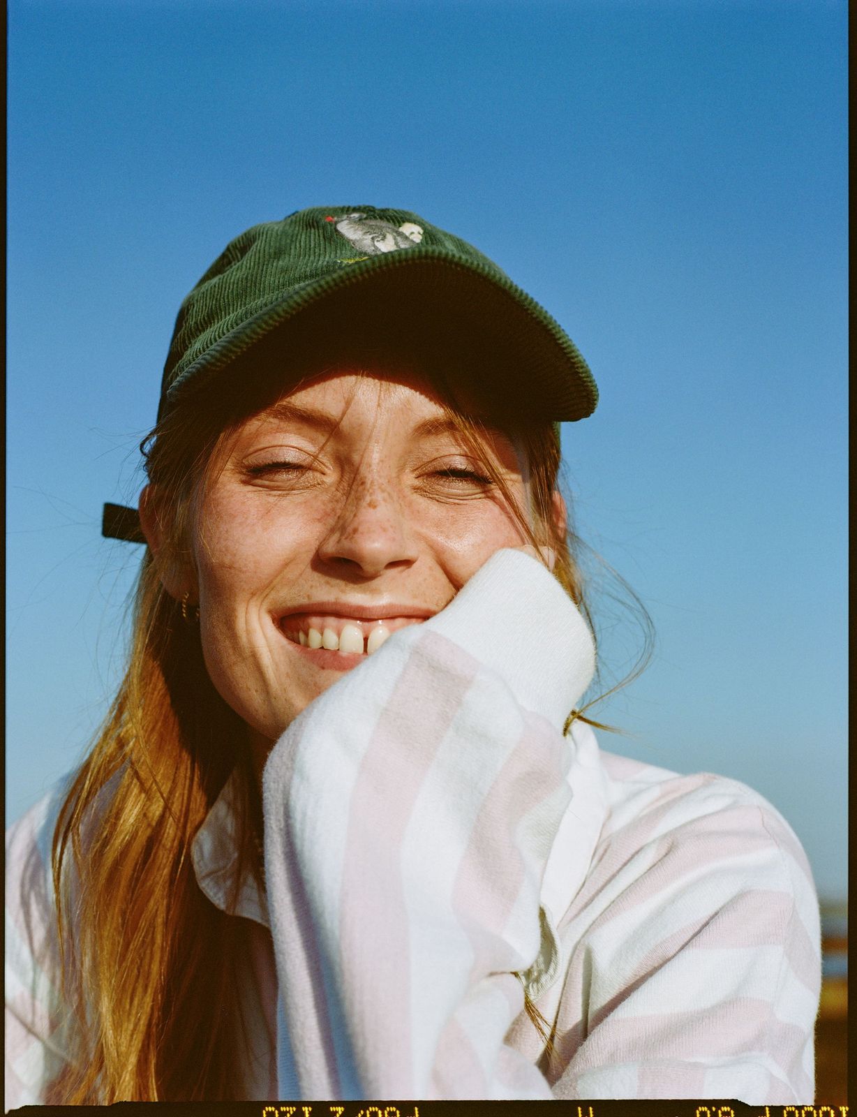 a woman wearing a green hat and a striped shirt