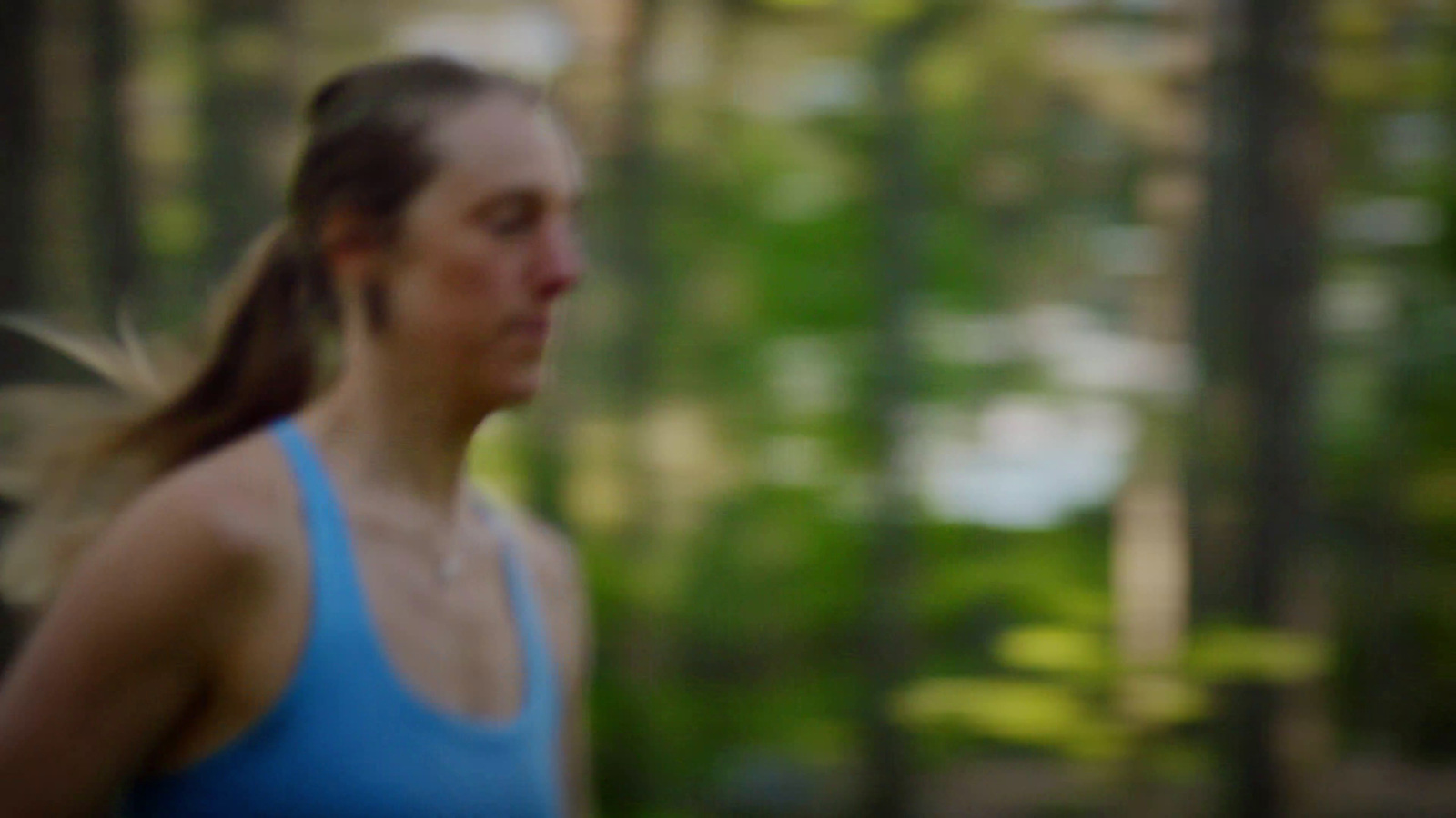 a blurry photo of a woman running in the woods