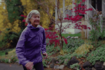 a woman in a purple jacket walking down a street