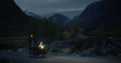  a man riding a bike down a dirt road