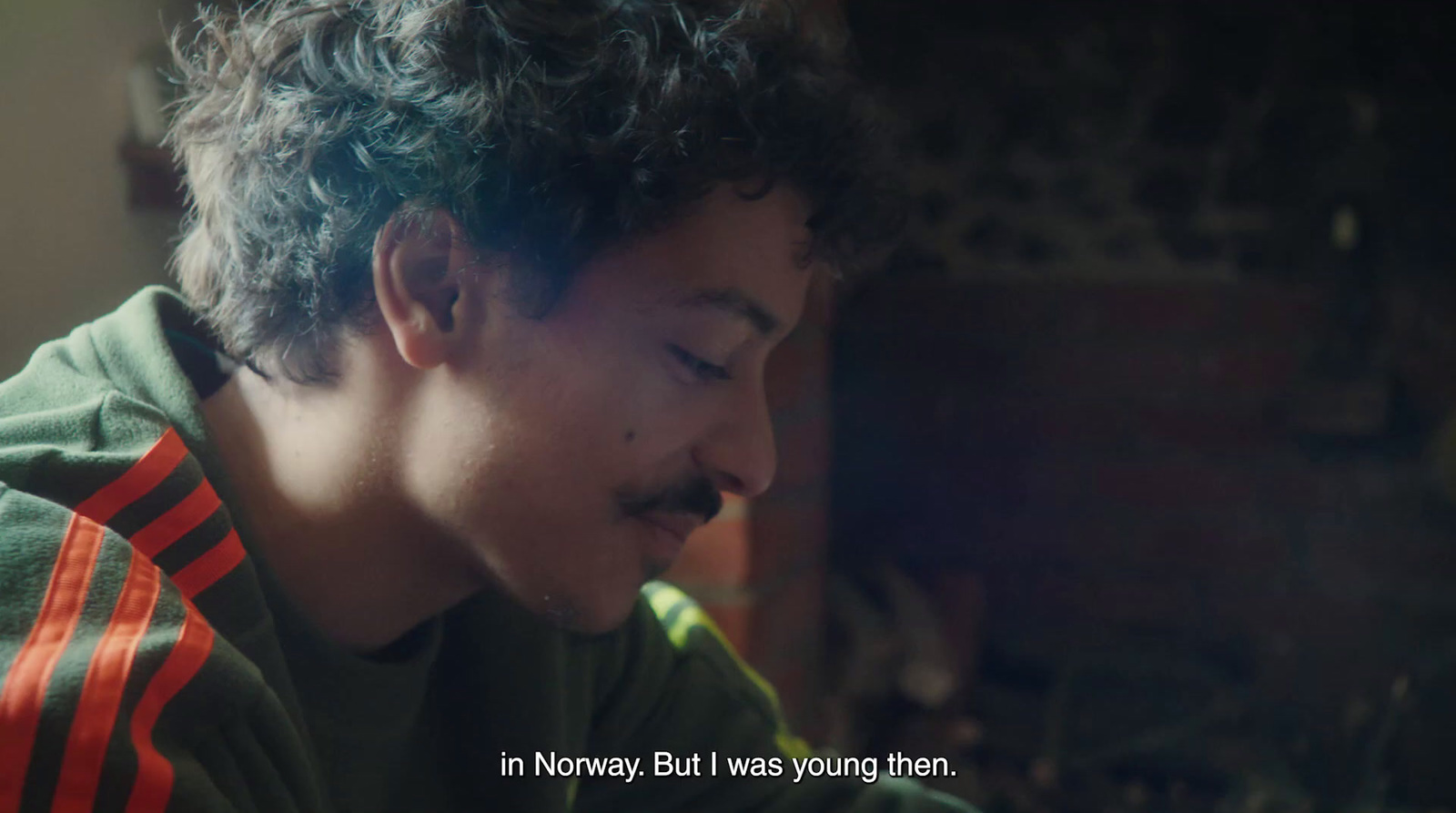  a young man with curly hair and a moustache