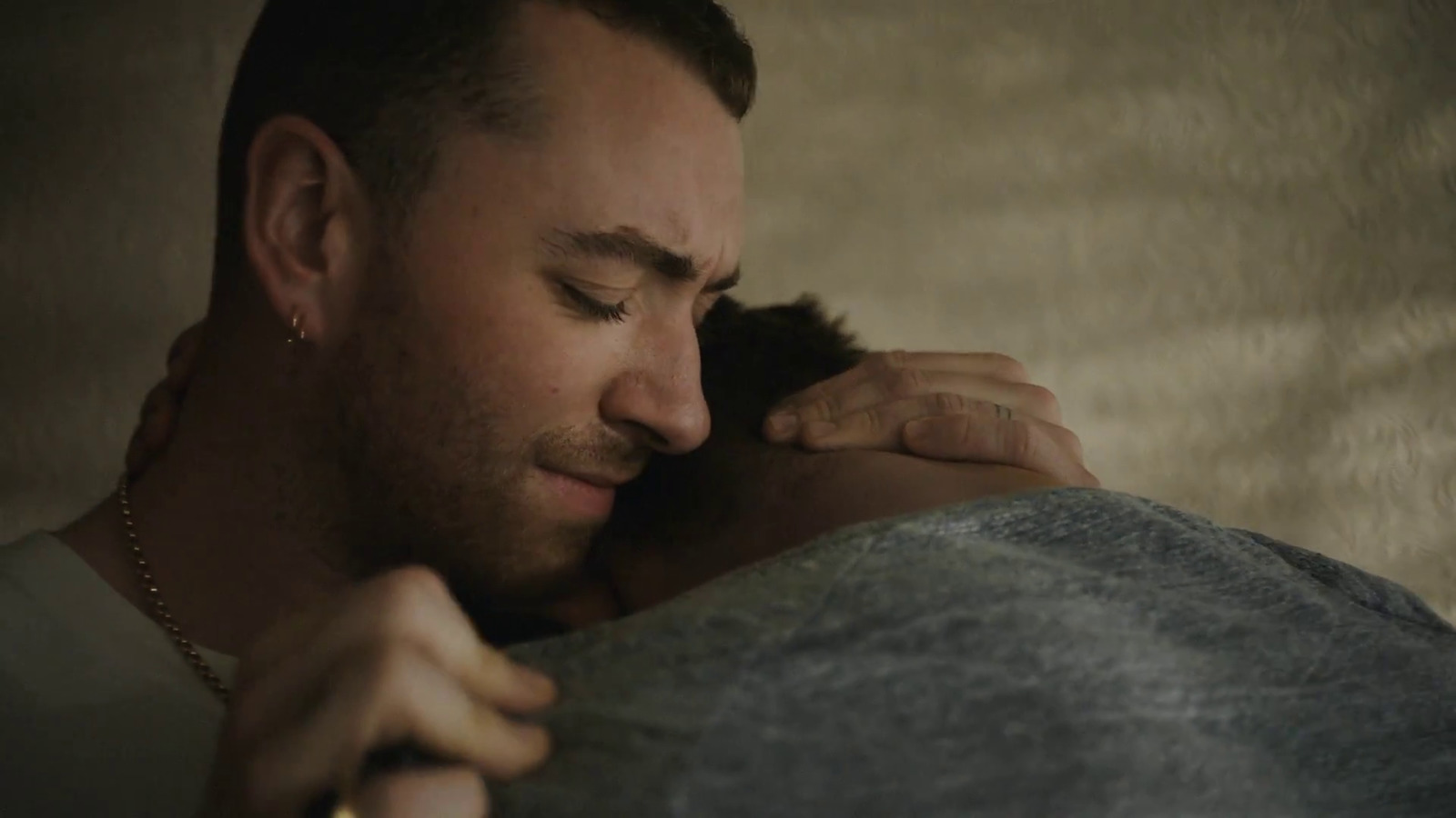 a man is hugging another man in a dark room