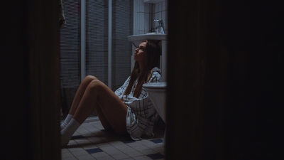 a woman sitting on the floor in a bathroom