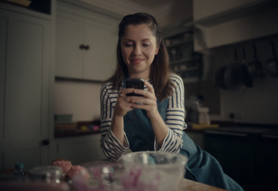 a woman sitting at a table looking at her cell phone