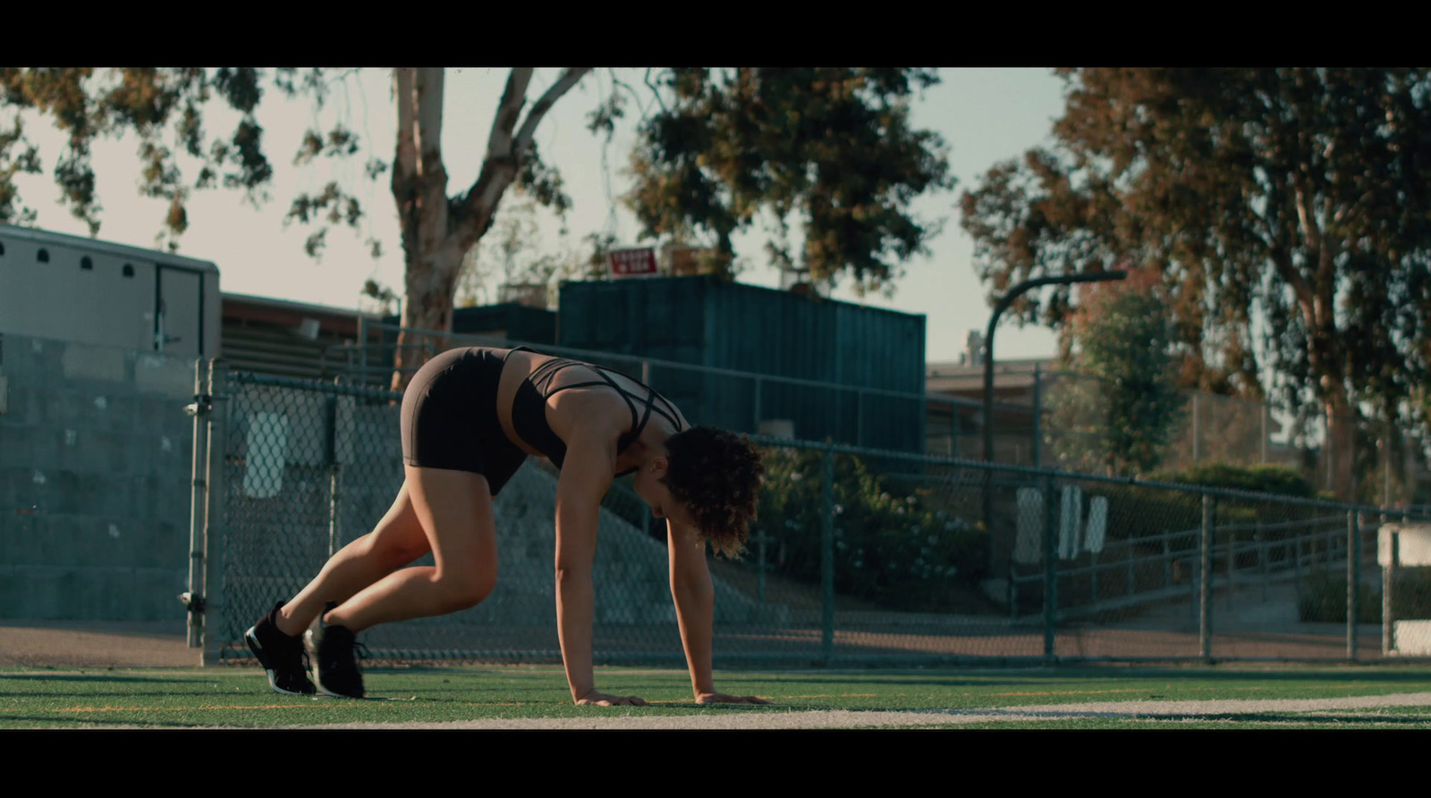 a woman is bending over on the grass