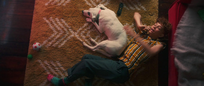 a young boy laying on the floor next to a dog