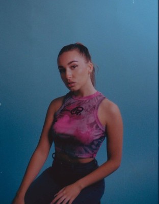 a woman is posing for a picture with a blue background