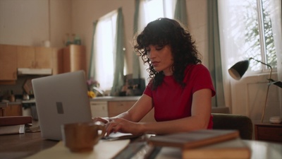 a woman sitting at a table using a laptop computer