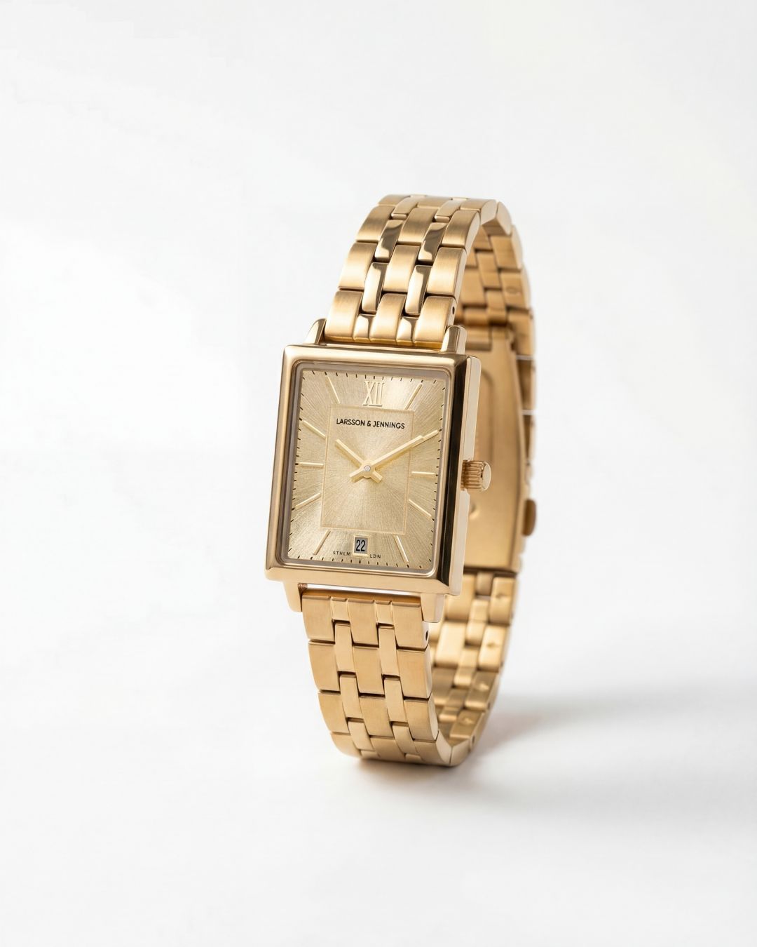 a gold watch sitting on a white surface