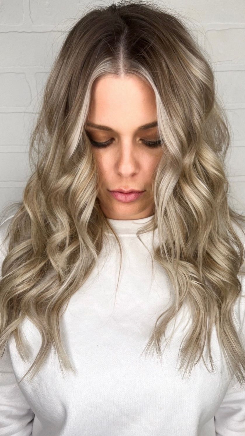 a woman with blonde hair wearing a white sweater