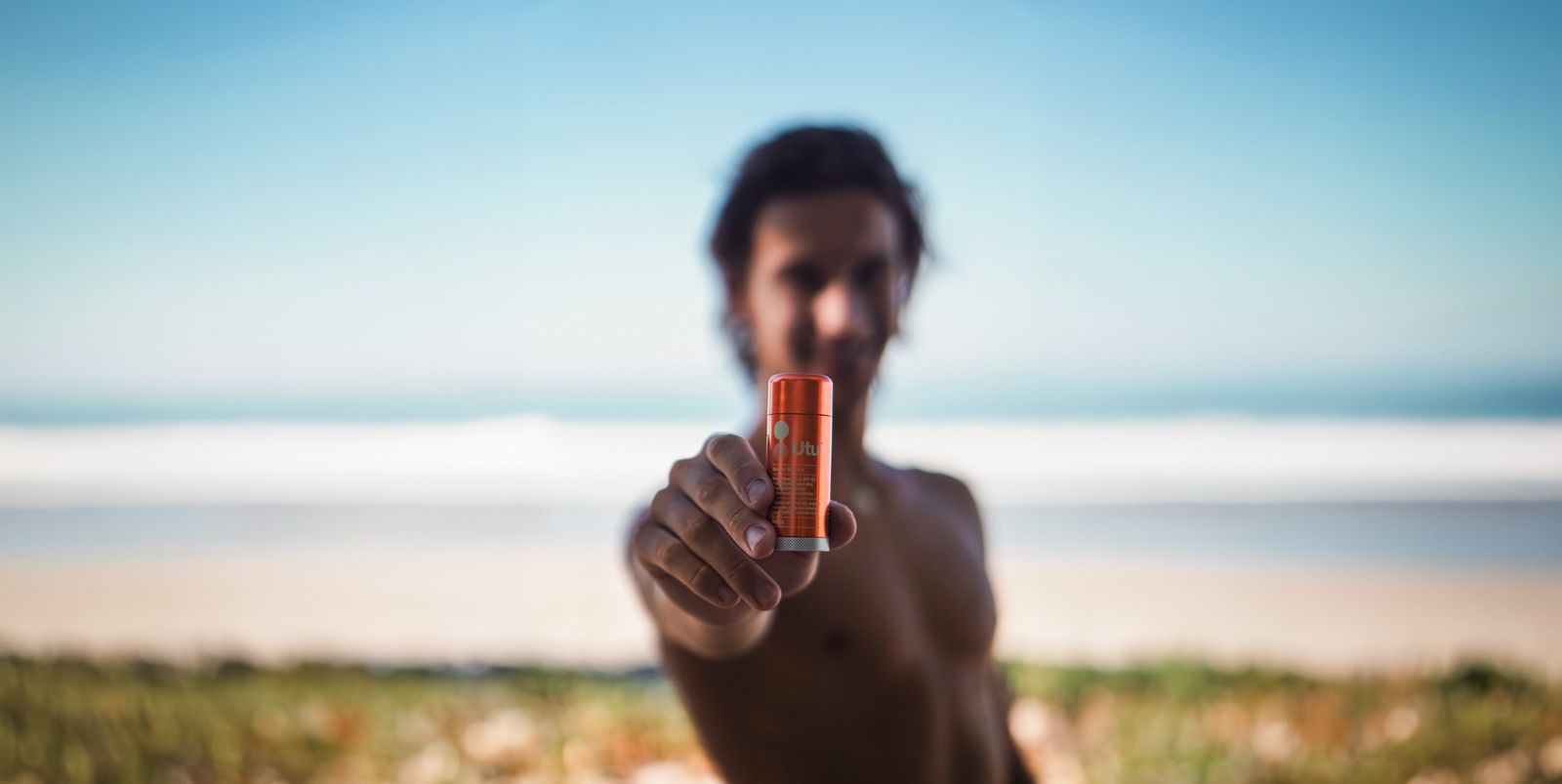 a man holding a battery in his hand on the beach