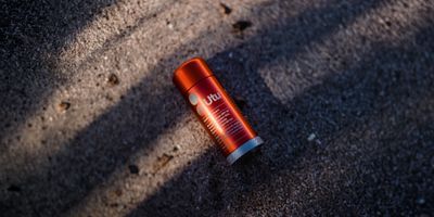 an orange lip bale sitting on the ground