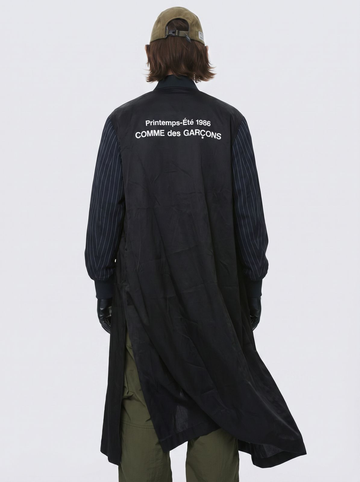 the back of a man wearing a black jacket and green pants