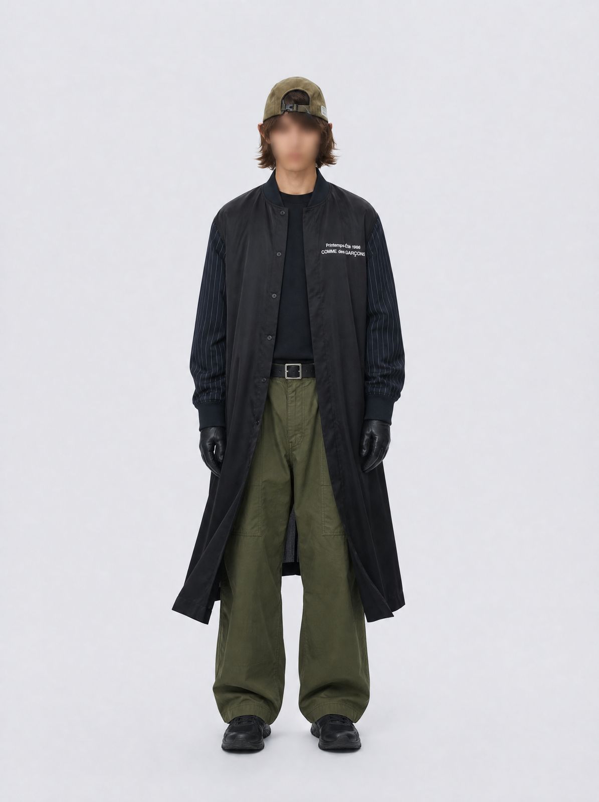a man wearing a black coat and green pants