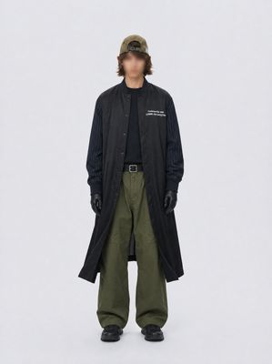 a man wearing a black coat and green pants