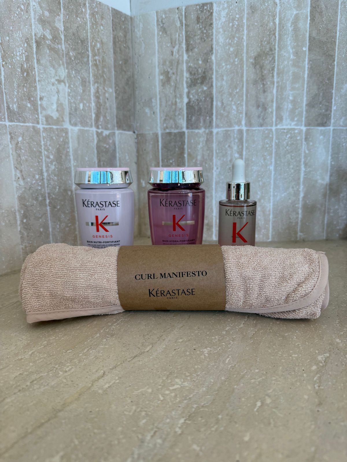 a towel and three bottles of kerasae on a counter