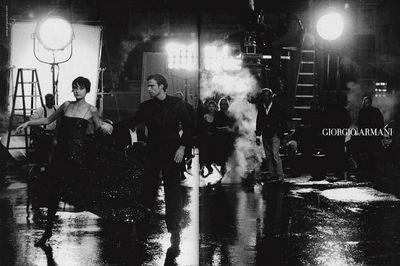 a black and white photo of a man and a woman walking in the rain