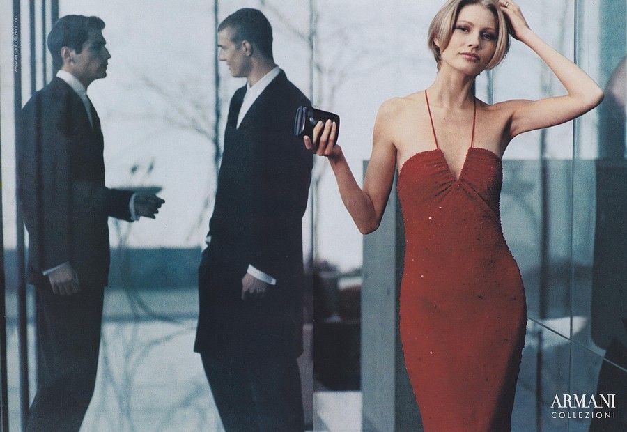 a woman in a red dress standing next to a man in a suit