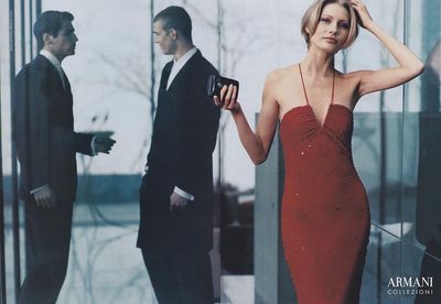 a woman in a red dress standing next to a man in a suit