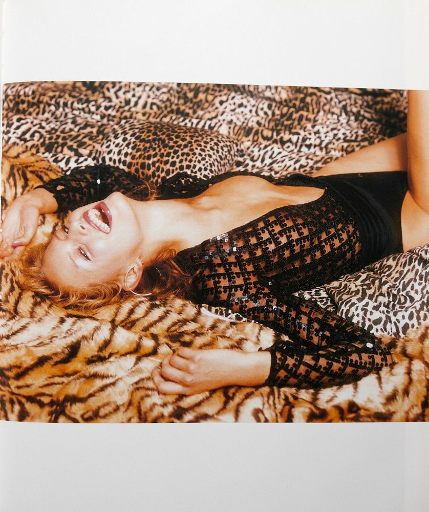 a woman laying on top of a leopard print blanket