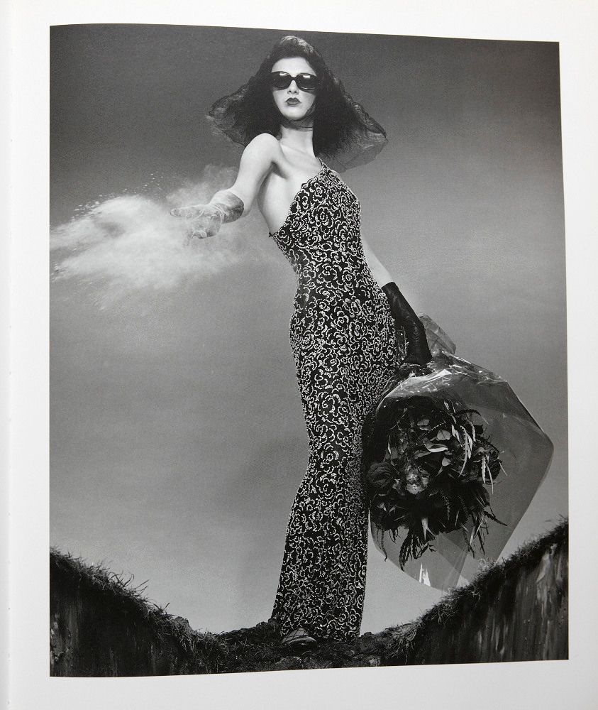 a black and white photo of a woman holding an umbrella