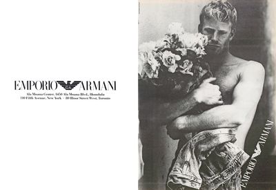 a shirtless man holding a bouquet of flowers