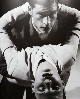 a black and white photo of a man with his hands on his head