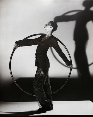 a man holding a large metal hoop in front of his face