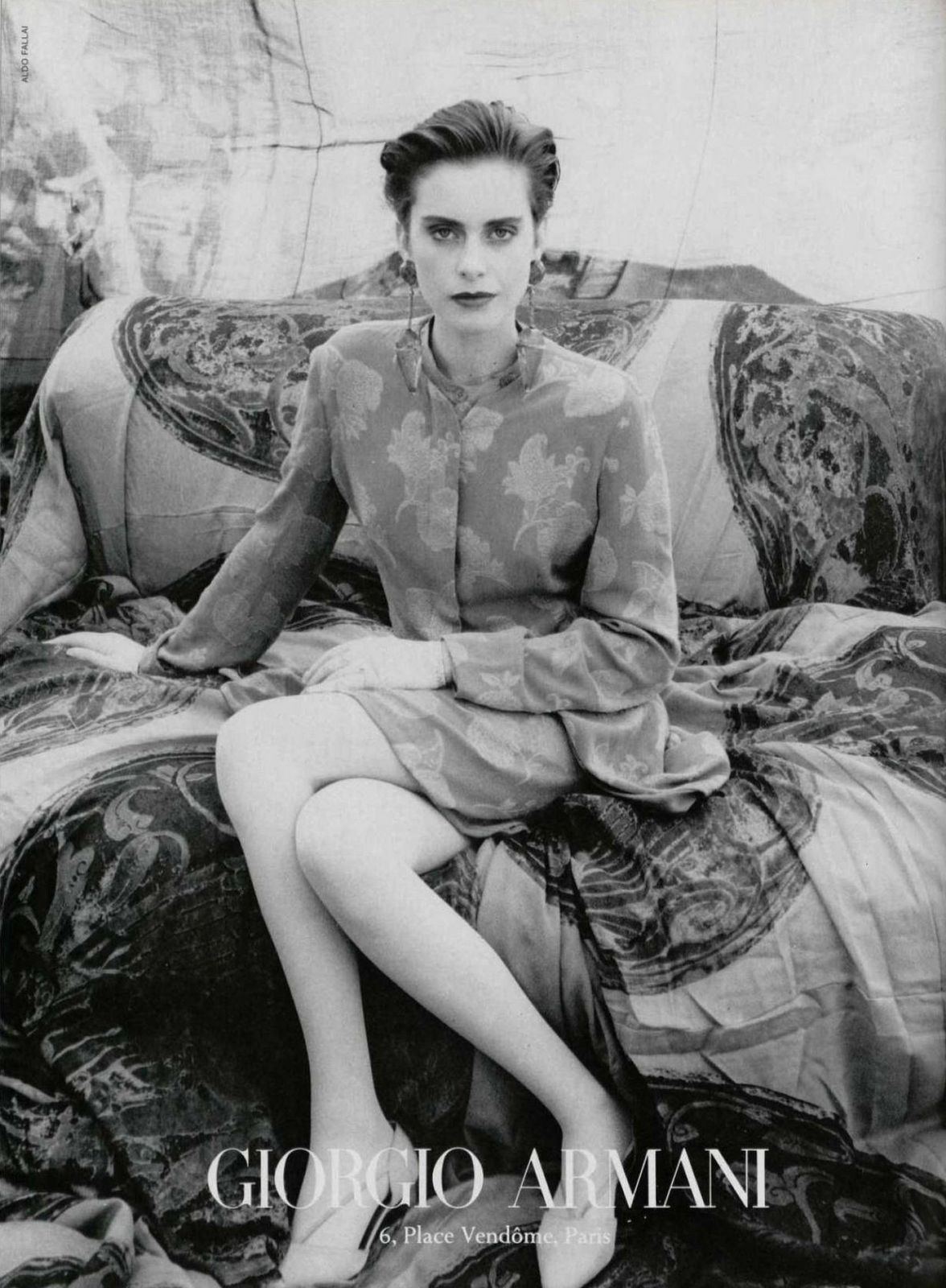 a black and white photo of a woman sitting on a couch