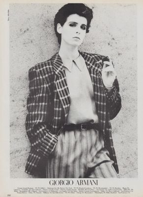 a black and white photo of a woman in a plaid jacket