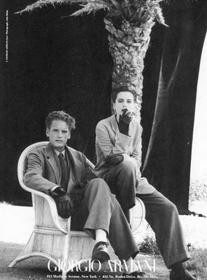 a black and white photo of two men sitting on a bench