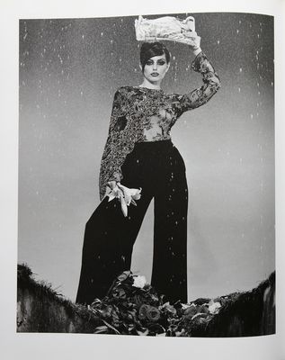 a black and white photo of a woman holding an umbrella