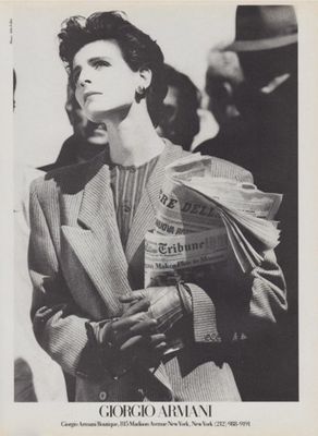 a black and white photo of a woman holding newspapers