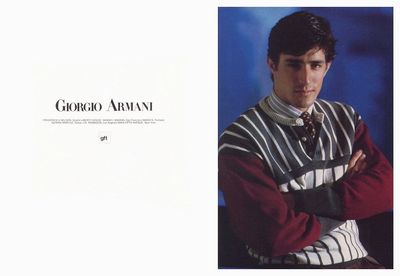 a man with his arms crossed wearing a striped sweater