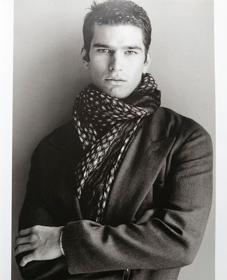 a black and white photo of a man wearing a scarf