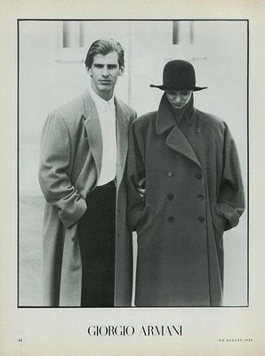 a black and white photo of two men in coats