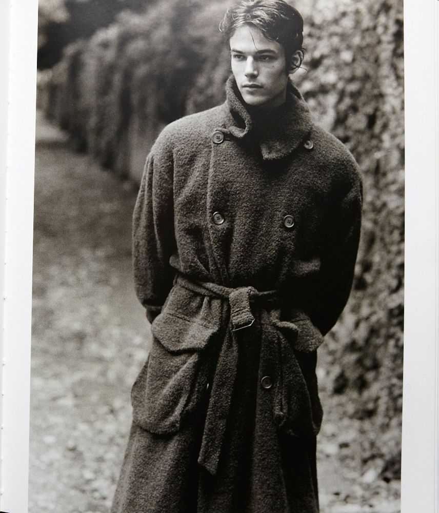 a black and white photo of a man in a trench coat