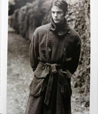 a black and white photo of a man in a trench coat