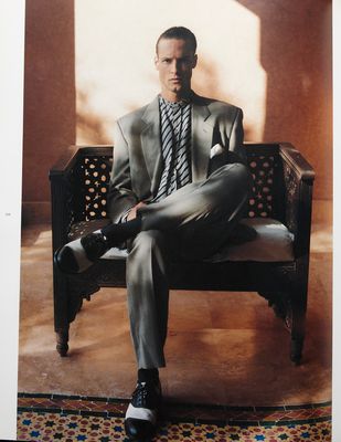 a man in a suit and tie sitting on a bench